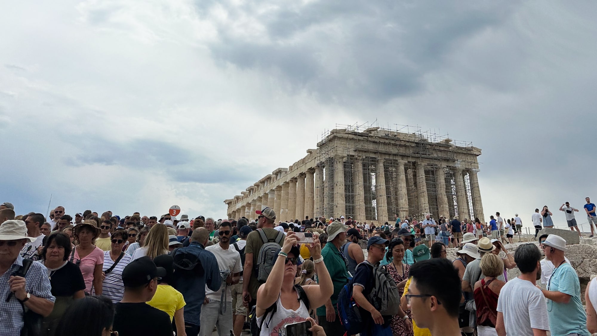 Lots of people crowding an under-construction Parthenon
